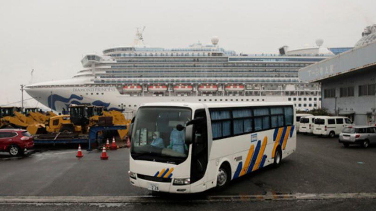 A bus leaves the quarantined Diamond Princess cruise ship at a port Sunday, Feb. 16, 2020, in...