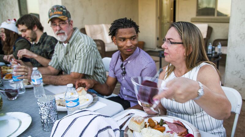 FILE - Jamal Hinton, center, Wanda Dench, right, and her family and friends, have Thanksgiving...