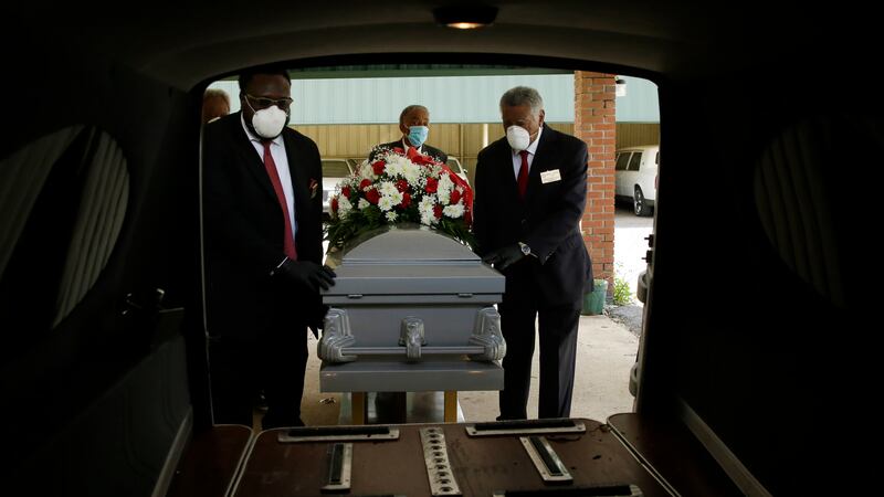 In this Saturday, April 18, 2020 photo, mortician Cordarial O. Holloway, foreground left,...