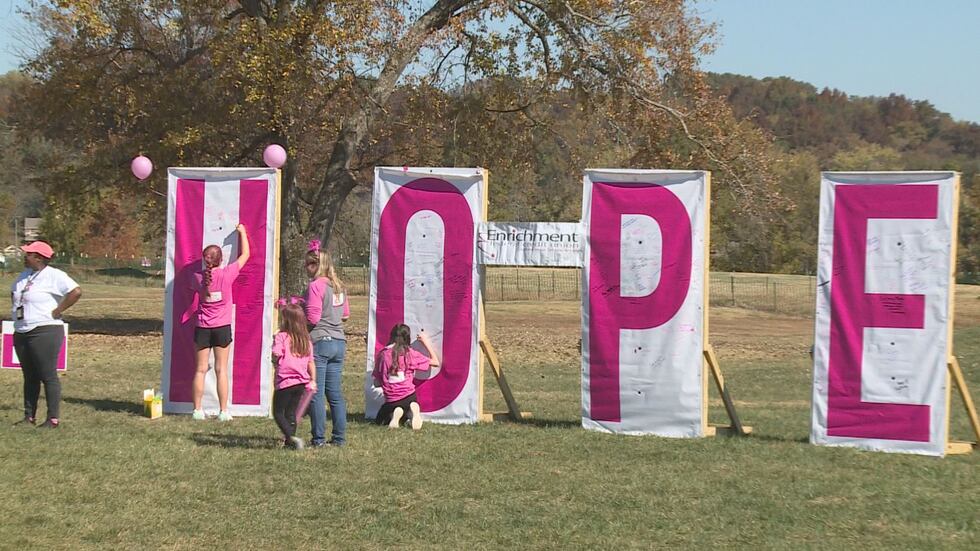 A young girl writes the name of a cancer survivor at the Making Strides Against Cancer walk on...