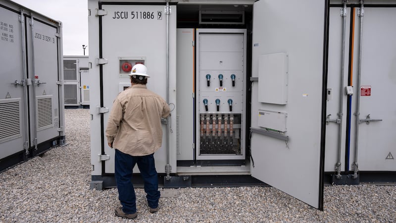 FILE - An employee works at a battery energy storage facility in Saginaw, Texas, April 25,...