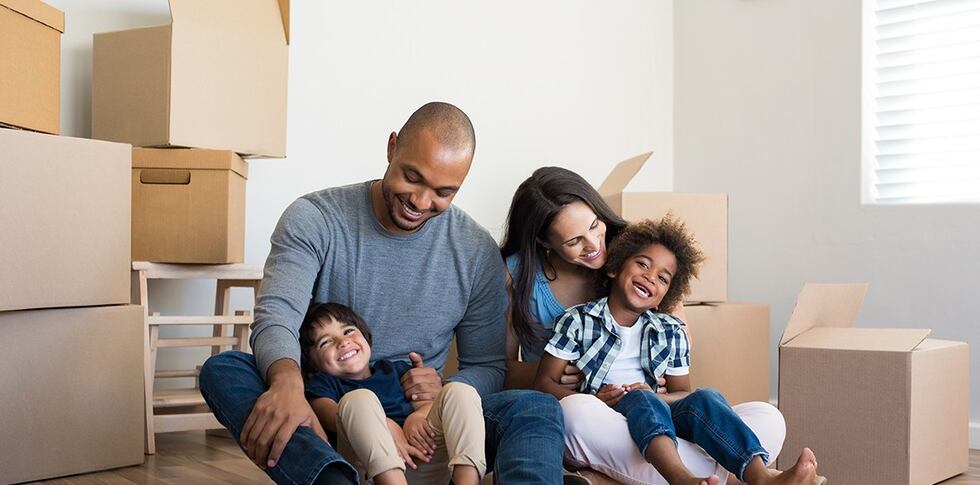 A family unpacks moving boxes in their new home.