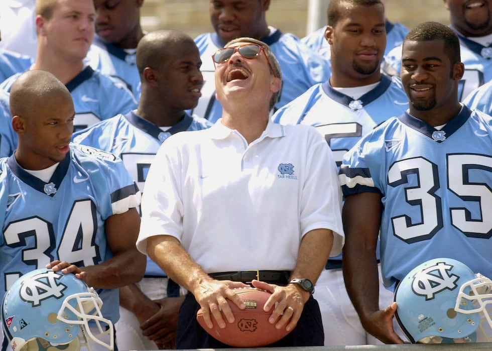 North Carolina football coach Carl Torbush, center, laughs at a photographers joke Wednesday,...