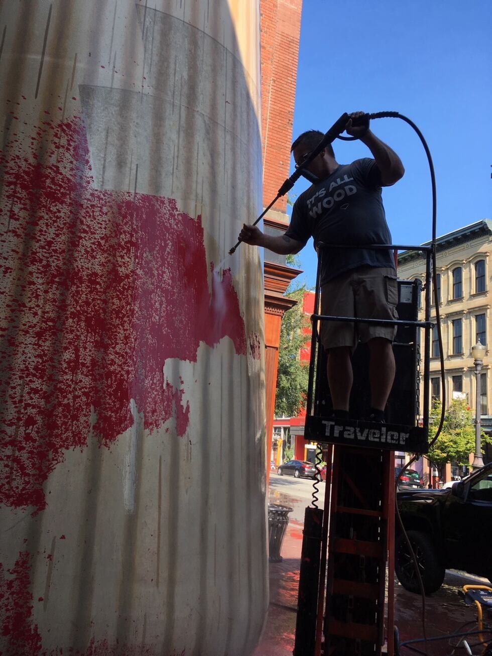 Crews work to clean the Big Bat outside of Louisville Slugger Museum.