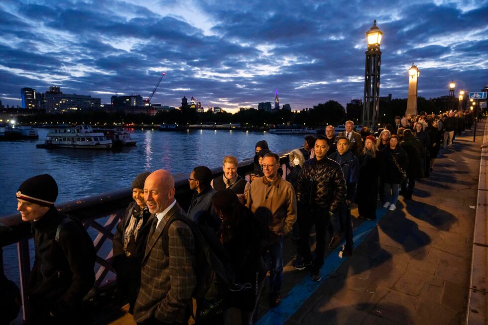 People stand in a queue to pay their respects to the late Queen Elizabeth II during the...